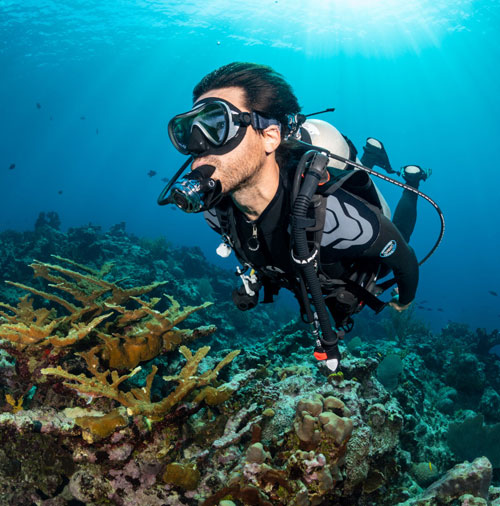 Diver swimming underwater wearing the Hydros Pro BCD