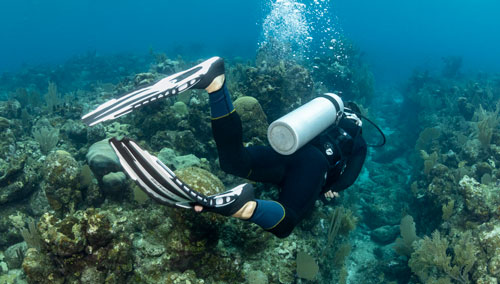 Underwater diver using the secure super cinch tank buckle system