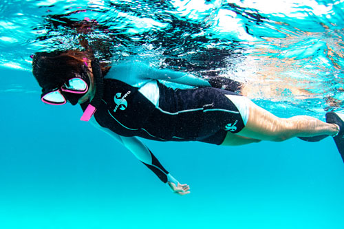 Woman snorkeler wearing SCUBAPRO Everflex 1.5mm Top and Shorts