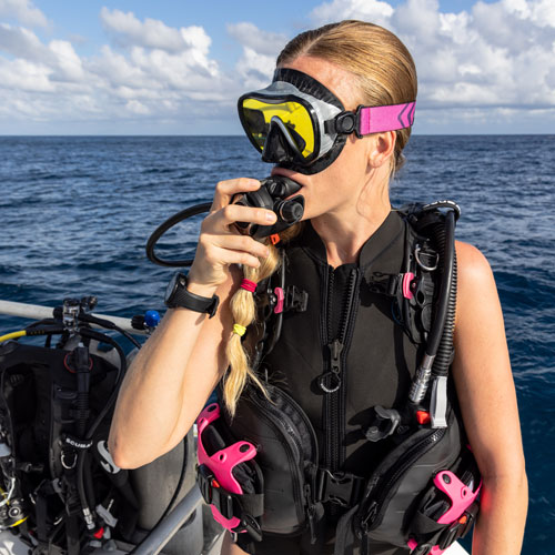 Woman diver on a boat wearing the Everflex YULEX Sleeveless Swimsuit