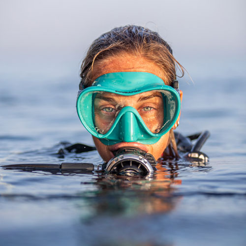 Woman with head above water wearing a SCUBAPRO mask and regulator