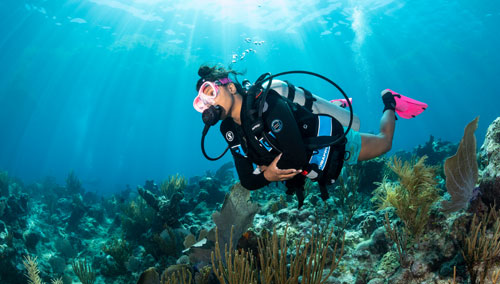 Woman diver exploring the ocean floor wearing the SCUBAPRO GO BCD