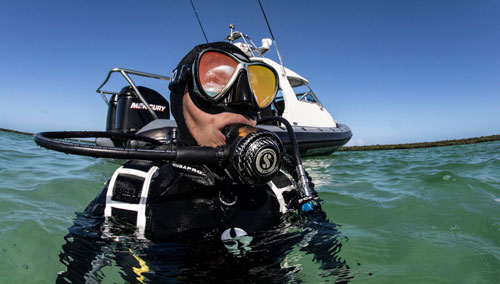 Diver in SCUBAPRO gear in the water near a boat