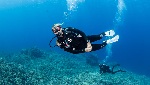 Woman diver underwater in the ocean wearing SCUBAPRO gear