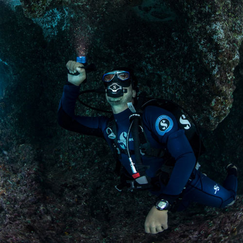 Diver exploring under water with a light