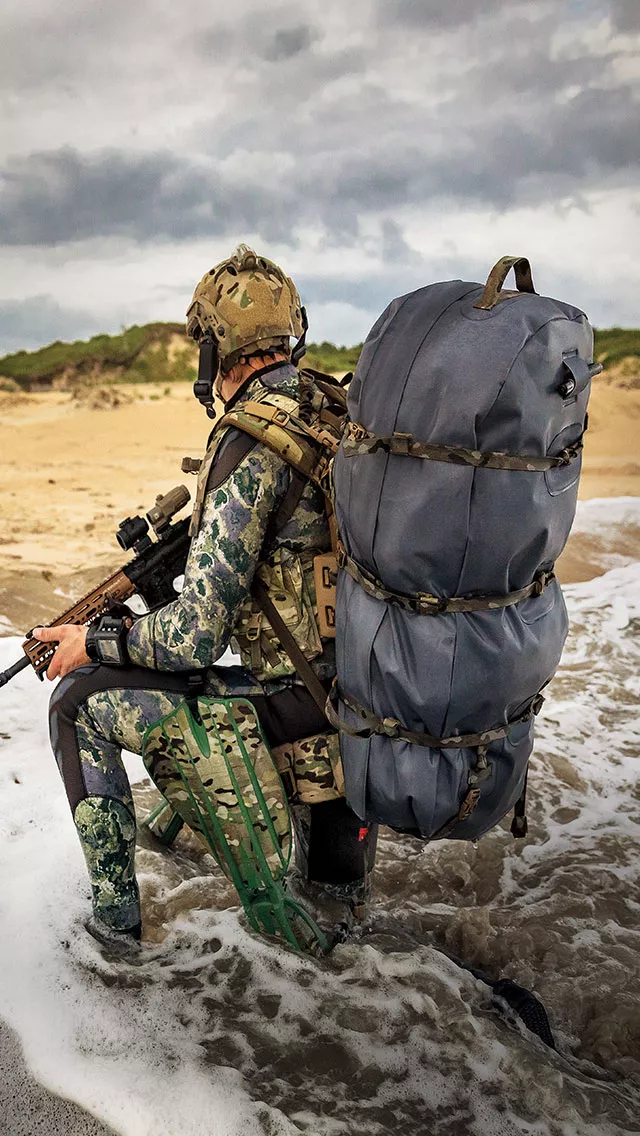 military man kneeling on the beach